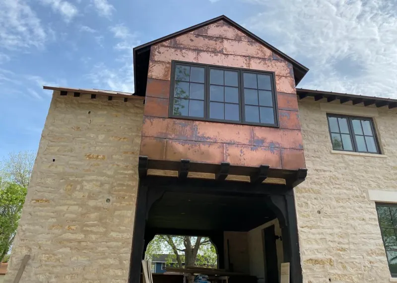 Copper metal panel facade on a stone building for Skylight Installation in Winona